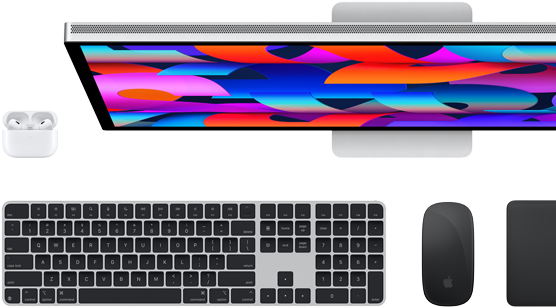 Un monitor Studio Display mostrato dall’alto insieme a una tastiera Magic Keyboard nera, un Magic Mouse nero, un Magic Trackpad nero e una custodia per AirPods bianca